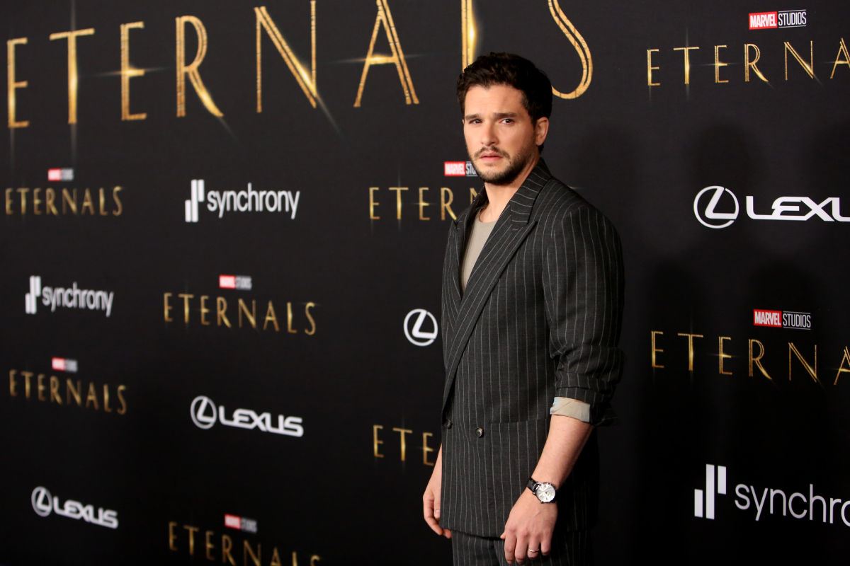 Kit Harington dans une veste et un t-shirt à fines rayures arrive à la première de Marvel Studios' Eternals le 18 octobre 2021 à Hollywood, Californie