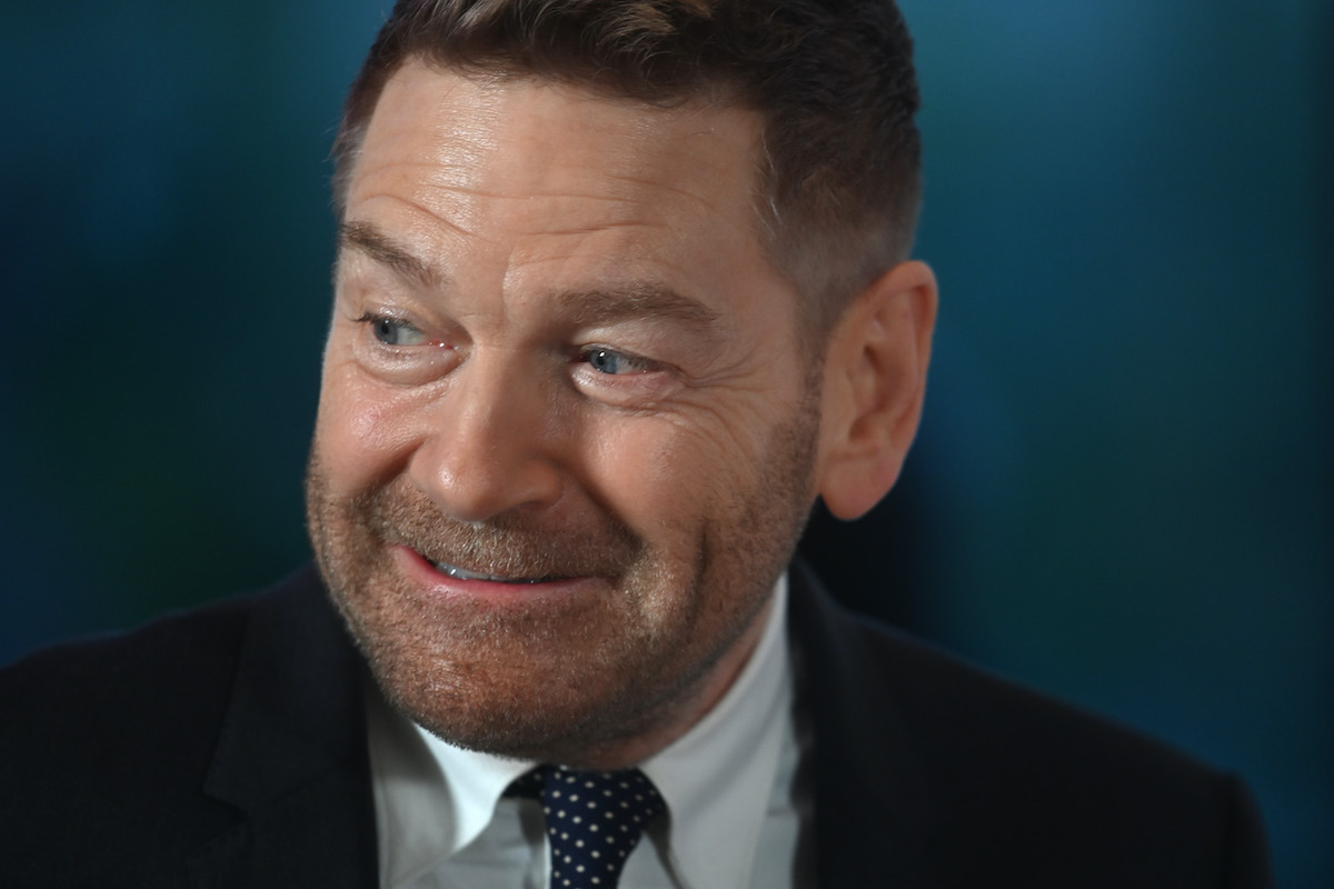 Kenneth Branagh porte un costume et sourit