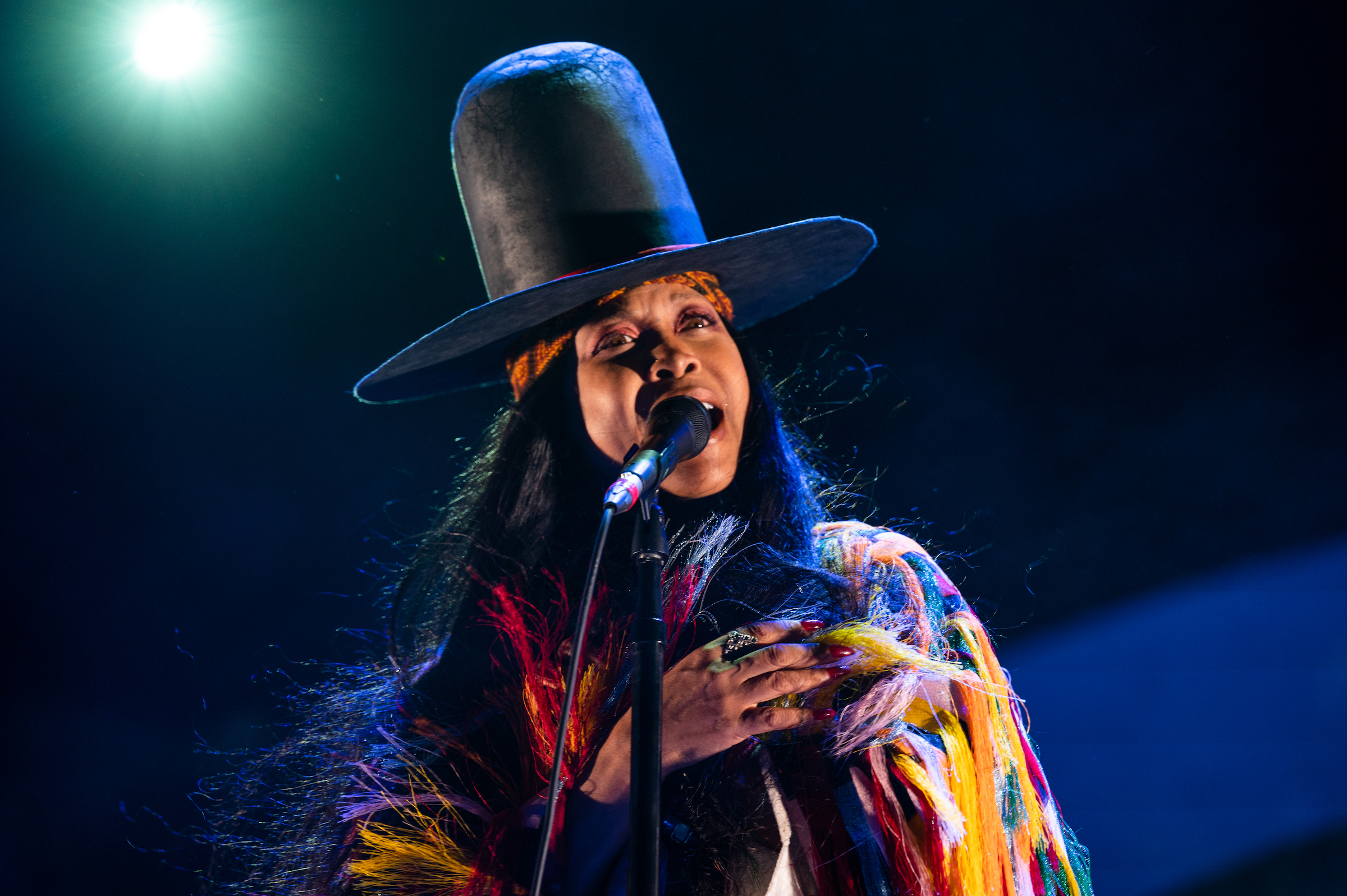 Erykah Badu portant un grand chapeau de cow-boy et chantant