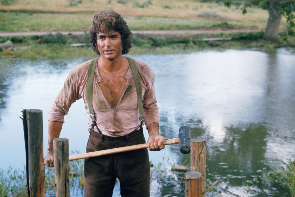 Michael Landon tient une hache sur le plateau de La petite maison dans la prairie.