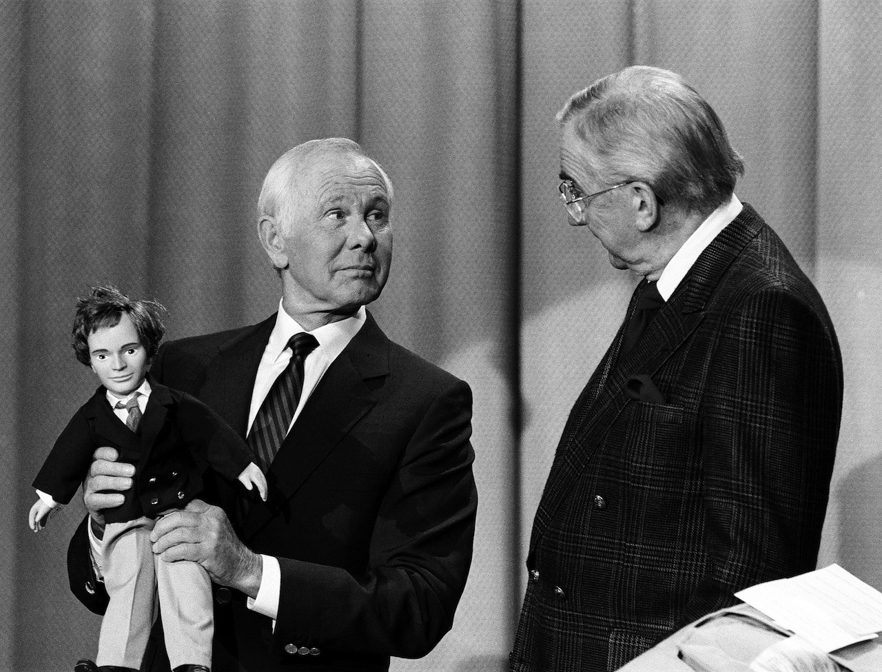 Johnny Carson tenant une poupée et regardant Ed McMahon dans