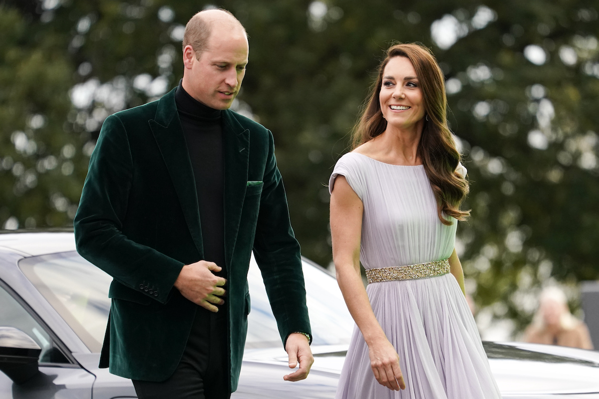 Le prince William porte une veste verte alors qu'il marche à côté de Kate Middleton dans une robe bleue