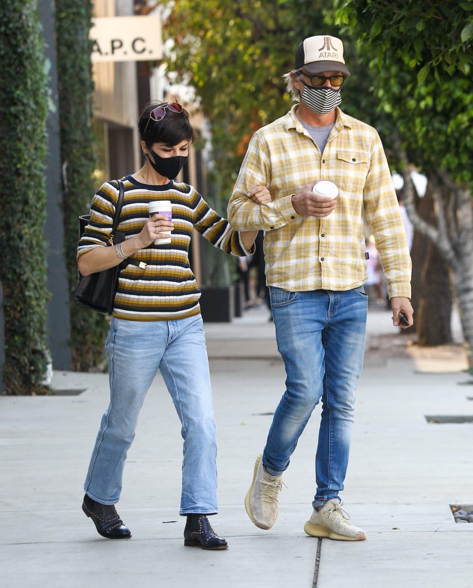 Selma Blair et Ron Carlson marchant ensemble dehors avec un café à la main