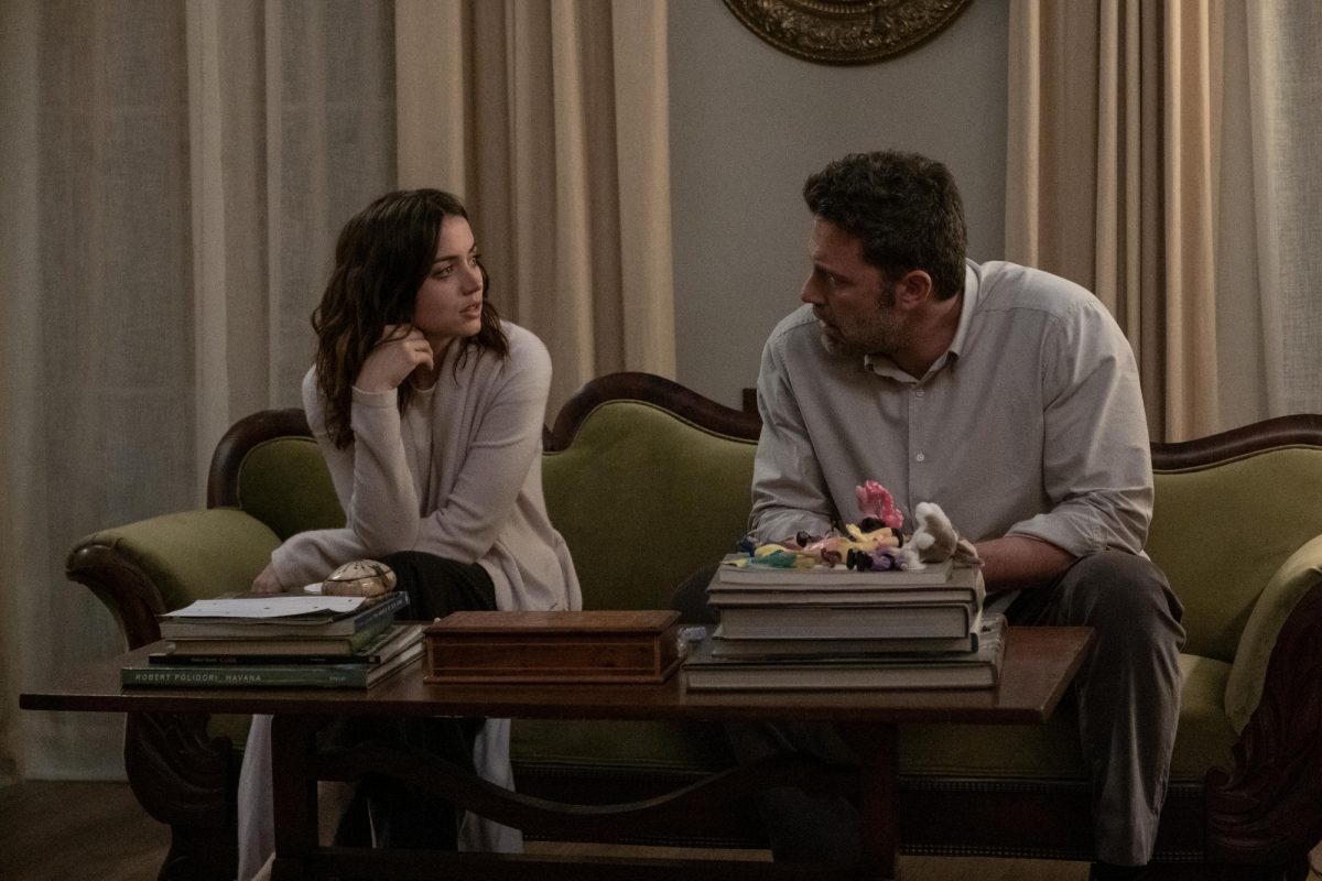 'Deep Water' Ana de Armas dans le rôle de Melinda Van Allen et Ben Affleck dans le rôle de Vic Van Allen assis sur un canapé se regardant
