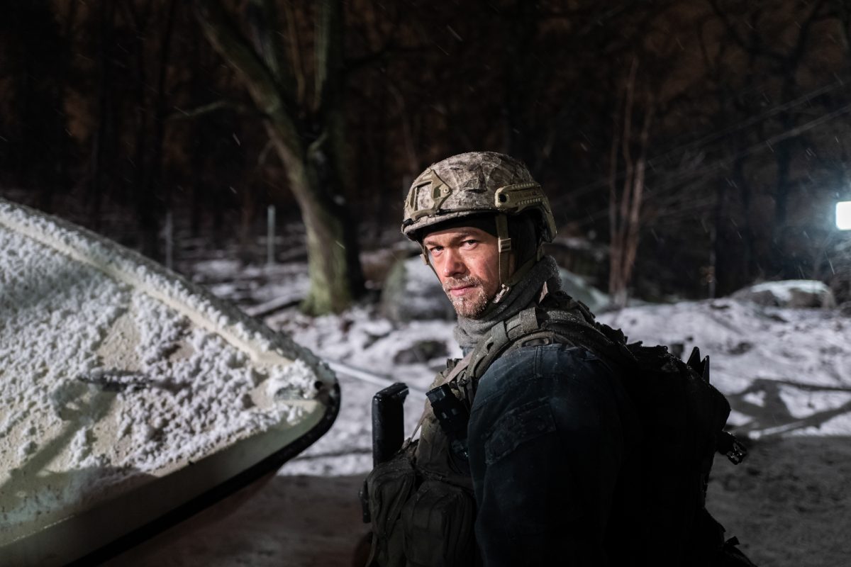 'Black Crab' Jakob Oftebro dans le rôle de Nylund regardant derrière portant un uniforme de combat dans la neige