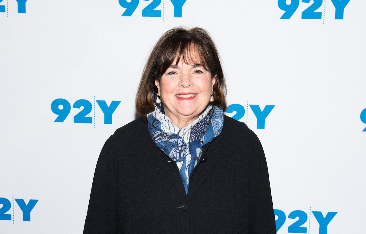 Ina Garten sourit vêtue d'une chemise noire et d'un foulard imprimé bleu et blanc
