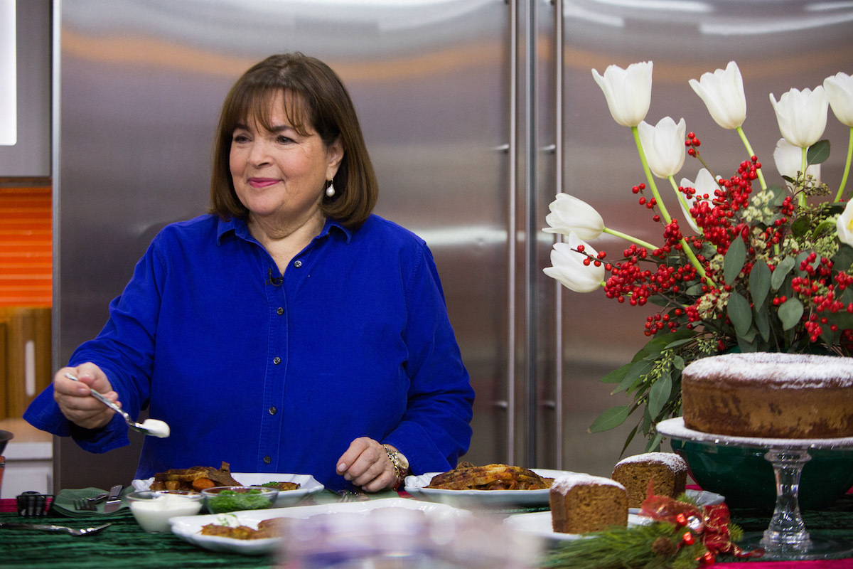 Barefoot Contessa Ina Garten tient une cuillère et regarde porter une chemise bleue lors d'une démonstration de cuisine