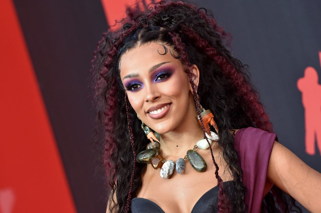 Doja Cat sur un tapis rouge portant des cheveux noirs et violets