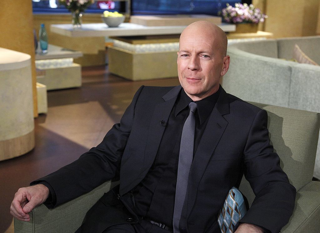 Bruce Willis portant un costume noir et une cravate sur le plateau de GMA.