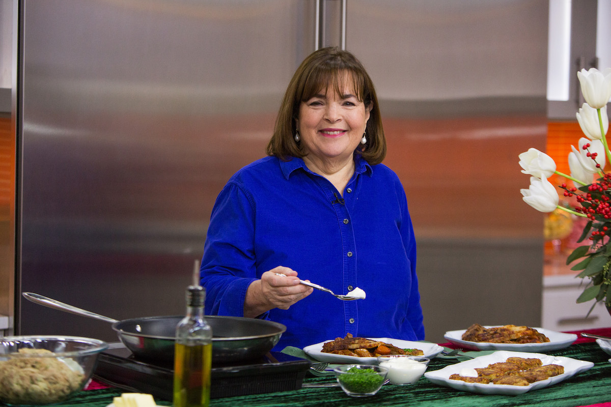 Barefoot Contessa Ina Garten sourit en tenant une cuillère tout en portant une chemise bleue