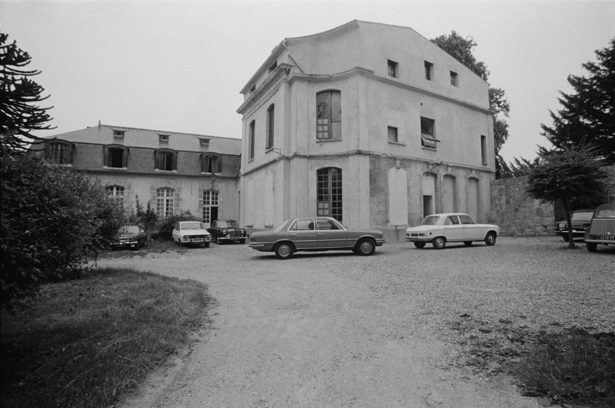 Une photo en noir et blanc du Château d'Hérouville avec plusieurs voitures garées devant.  Stevie Nicks détestait le temps qu'elle passait ici.
