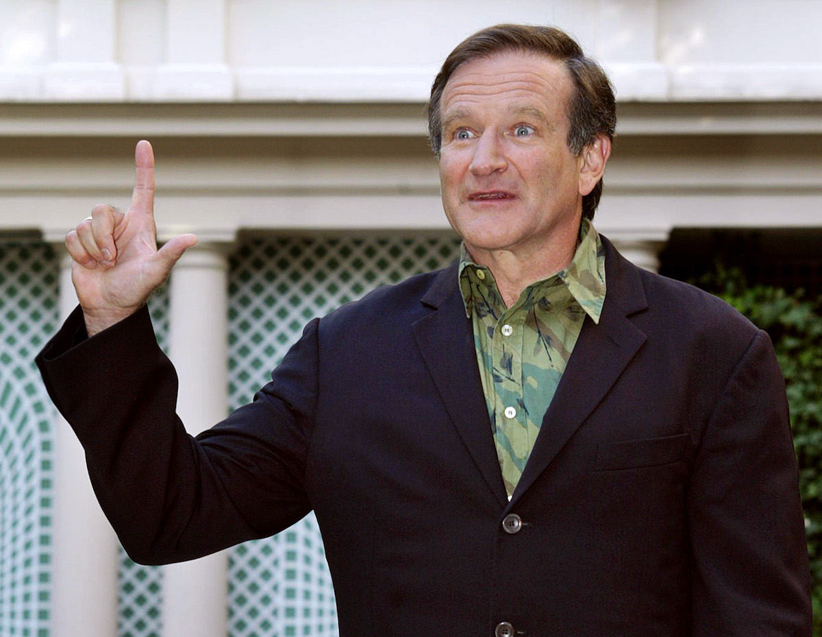 Robin Williams lève un doigt et regarde