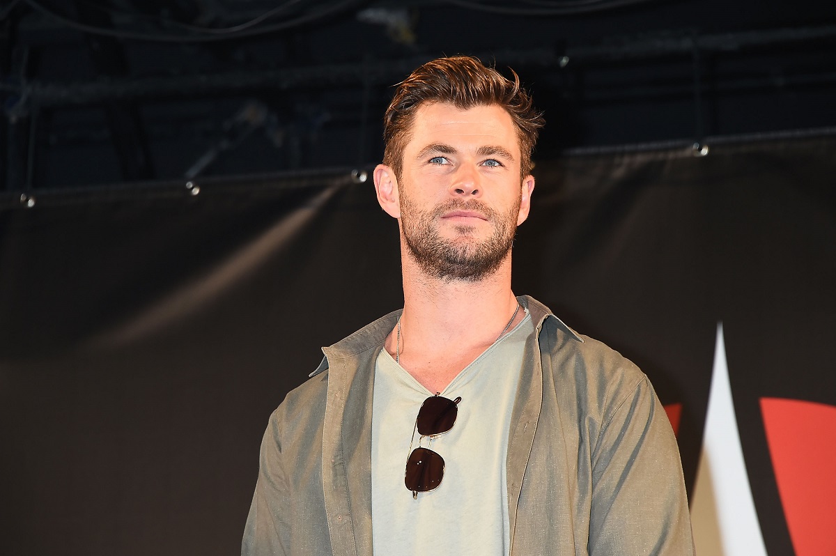 Chris Hemsworth posant en portant une veste grise.