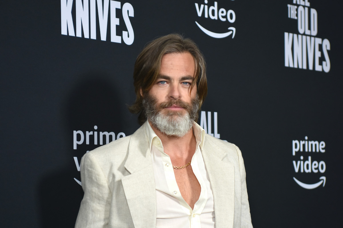 Chris Pine souriant devant un fond noir