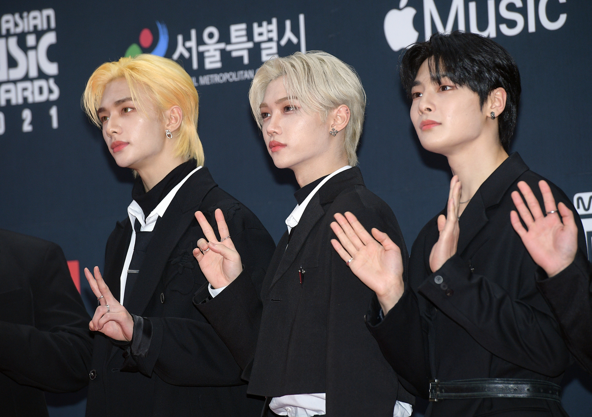 Hyunjin, Felix et IN en costume noir sur le tapis rouge des MAMA Awards à Séoul, en Corée.