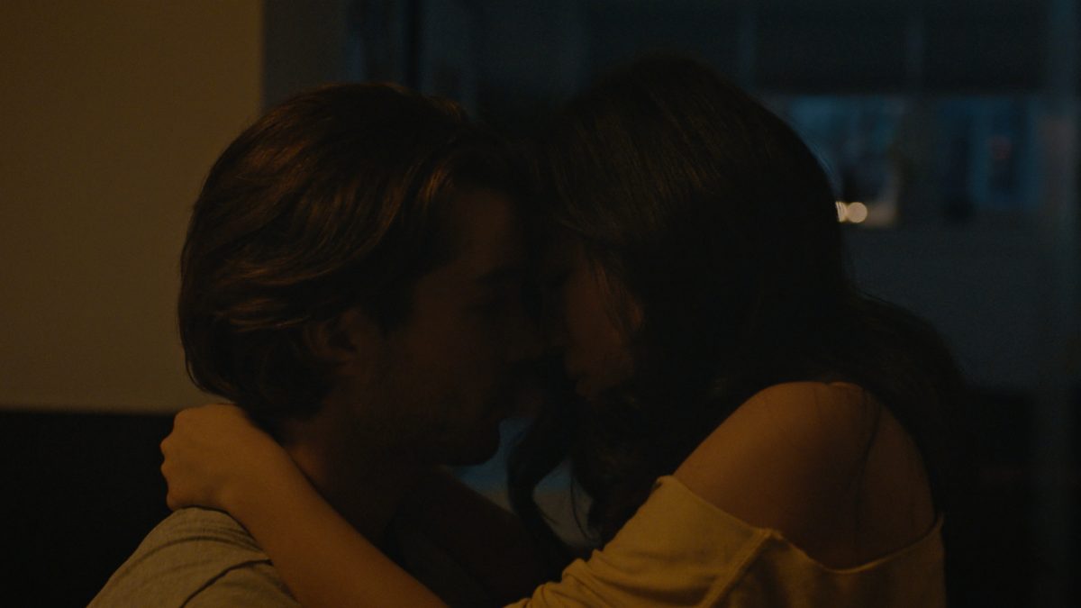 'Stay the Night' Joe Scarpellino dans le rôle de Carter et Andrea Bang dans le rôle de Grace s'embrassant dans un éclairage tamisé