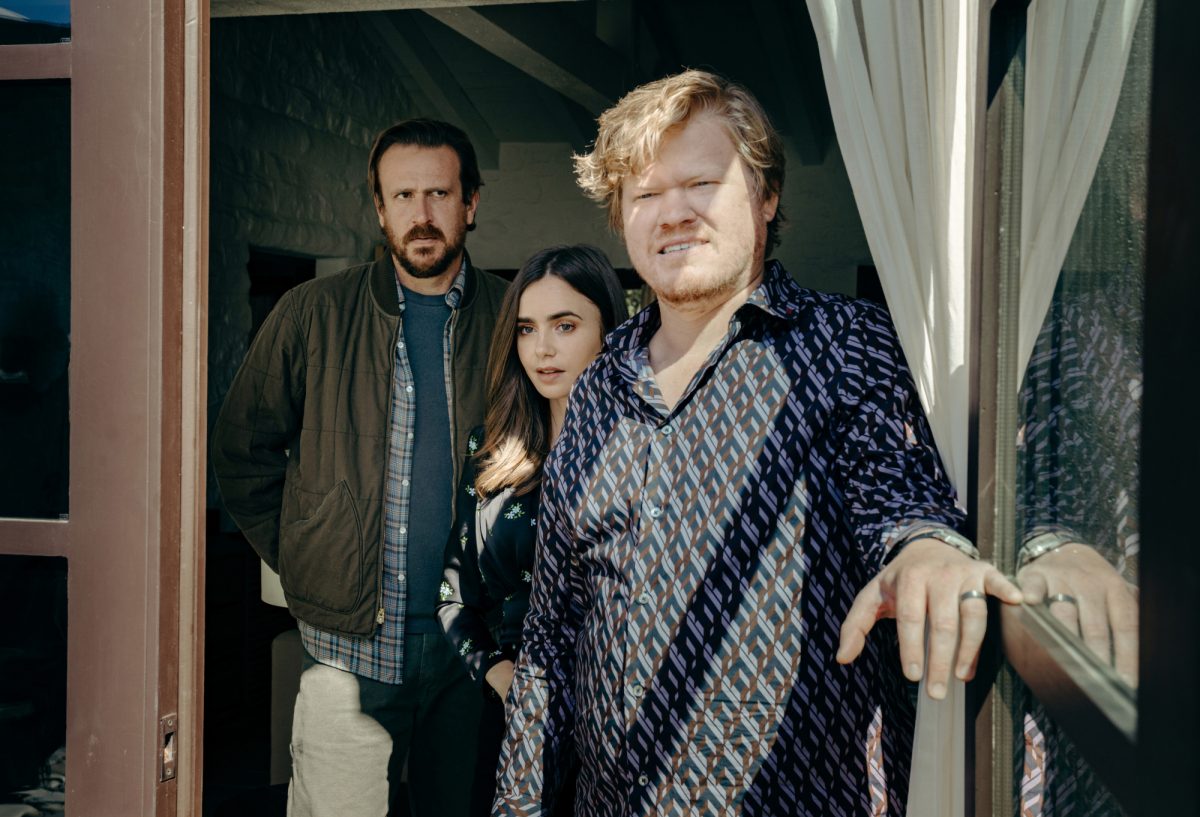 'Windfall' Jason Segel en tant que personne, Lily Colins en tant qu'épouse et Jesse Plemons en tant que PDG debout dans l'embrasure de la porte l'air inquiet