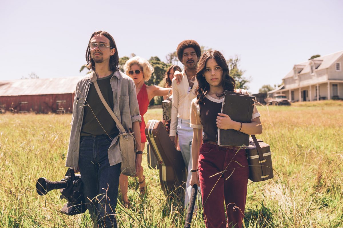 'X' Owen Campbell comme RJ, Brittany Snow comme Bobby-Lynne, Mia Goth comme Maxine, Scott Mescudi comme Jackson et Jenna Ortega comme Lorraine.  marcher dans l'herbe avec une maison en arrière-plan