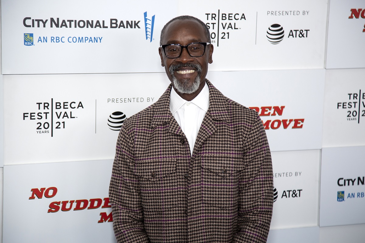 Don Cheadle souriant tout en portant une veste grise.