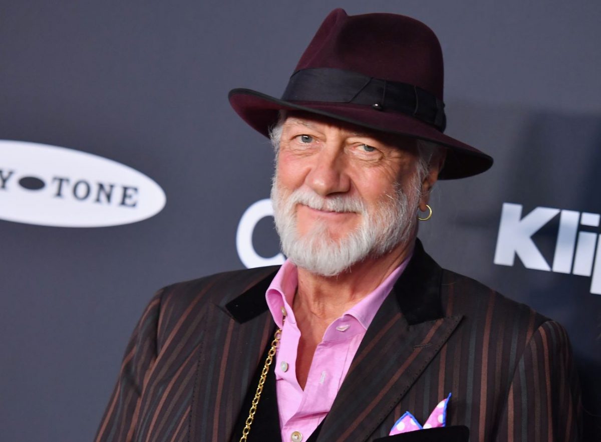 Mick Fleetwood porte un costume rayé, des bijoux en or et un chapeau.  Harry Styles en a fait le visage de sa marque de beauté.