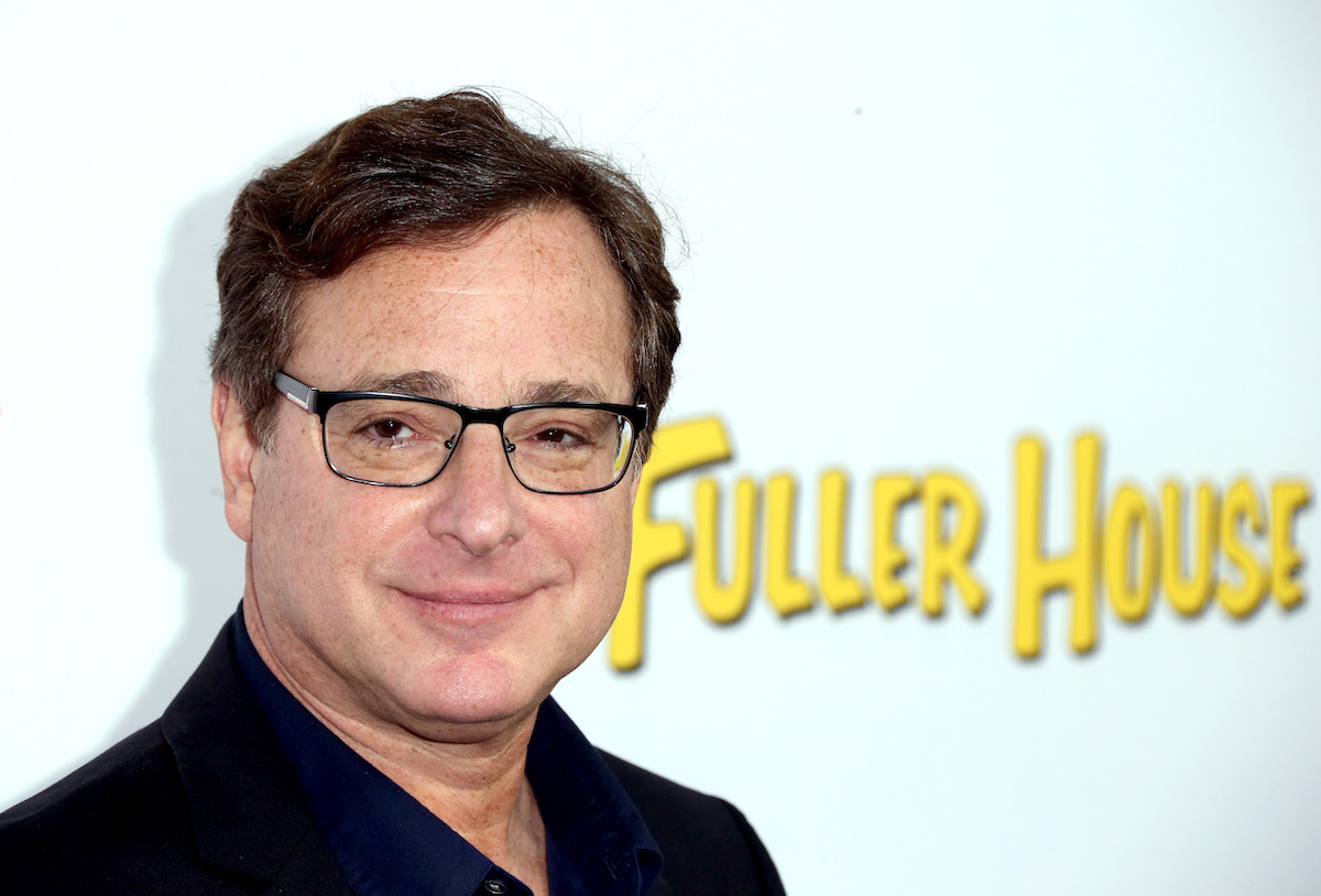 Bob Saget pose devant le logo 'Fuller House'.