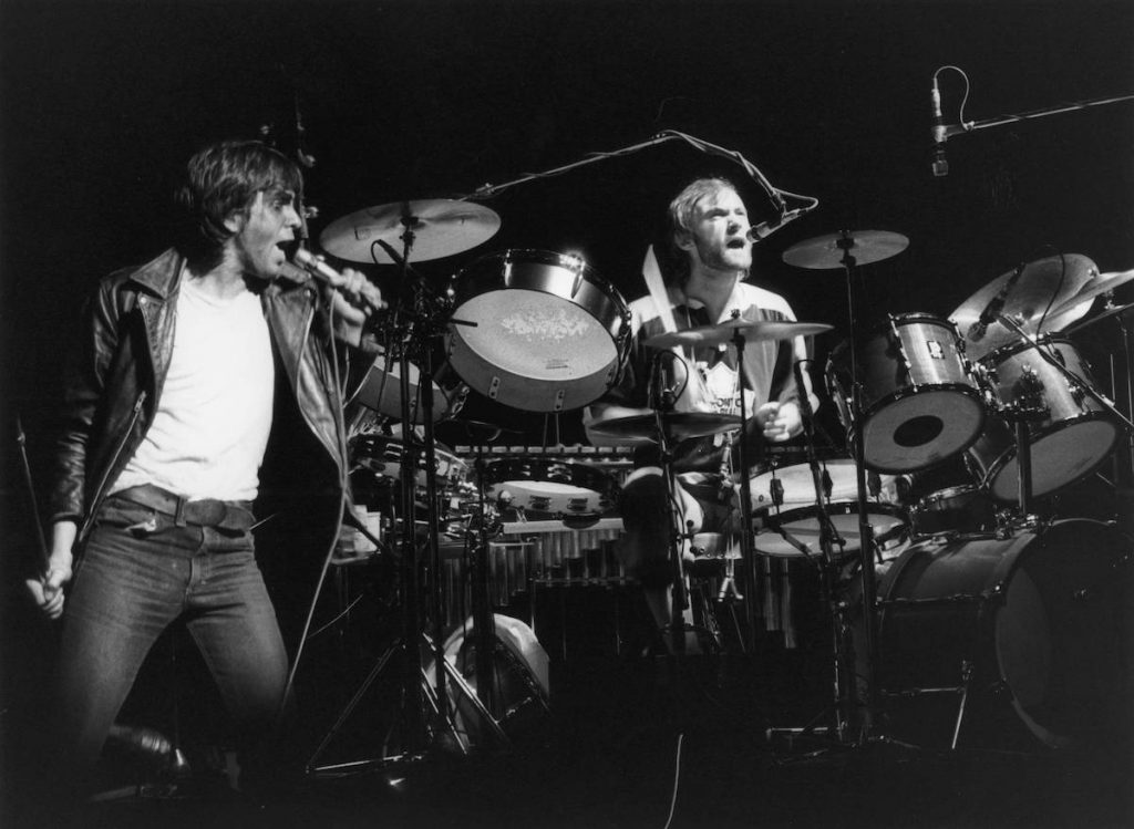 Les membres du groupe Genesis Peter Gabriel et Phil Collins chantent sur scène
