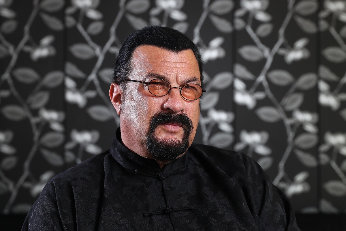 Steven Seagal posant en portant des lunettes de soleil.