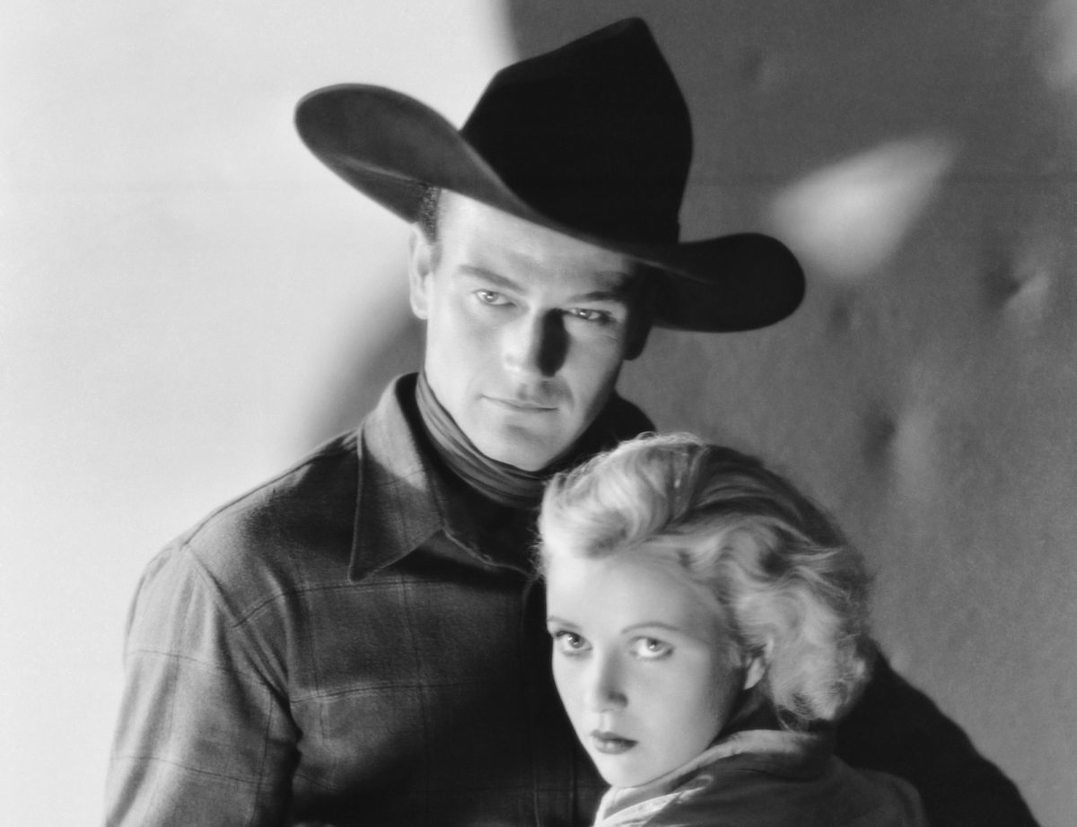 'Riders of Destiny' John Wayne dans le rôle de Singin' Sandy Saunders et Cecilia Parker dans le rôle de Fay Denton dans des vêtements occidentaux regardant la caméra