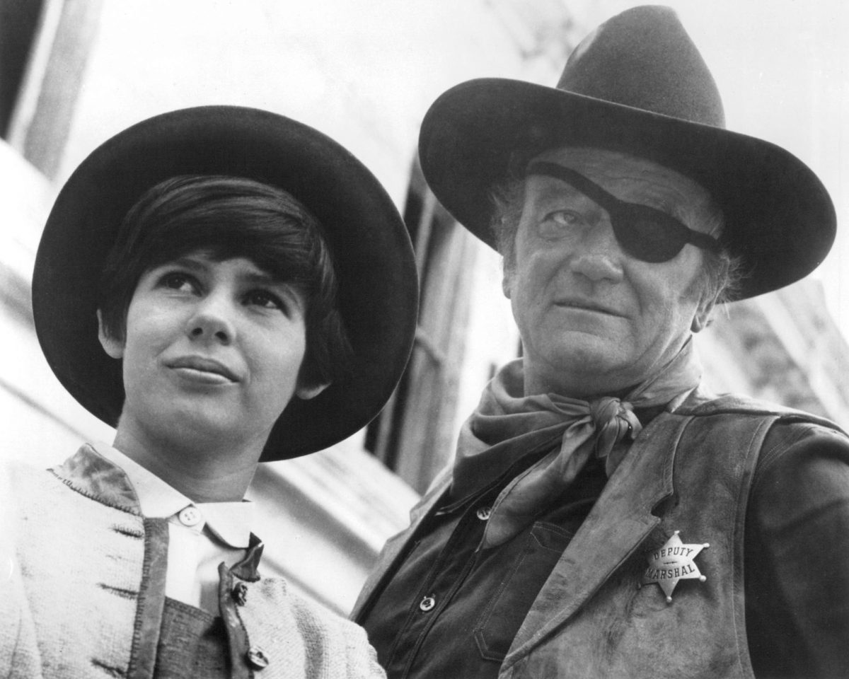 'True Grit' Kim Darby dans le rôle de Mattie Ross et John Wayne, lauréat d'un Oscar, dans le rôle de Rooster Cogburn portant des chapeaux de cow-boy et des vêtements occidentaux en noir et blanc