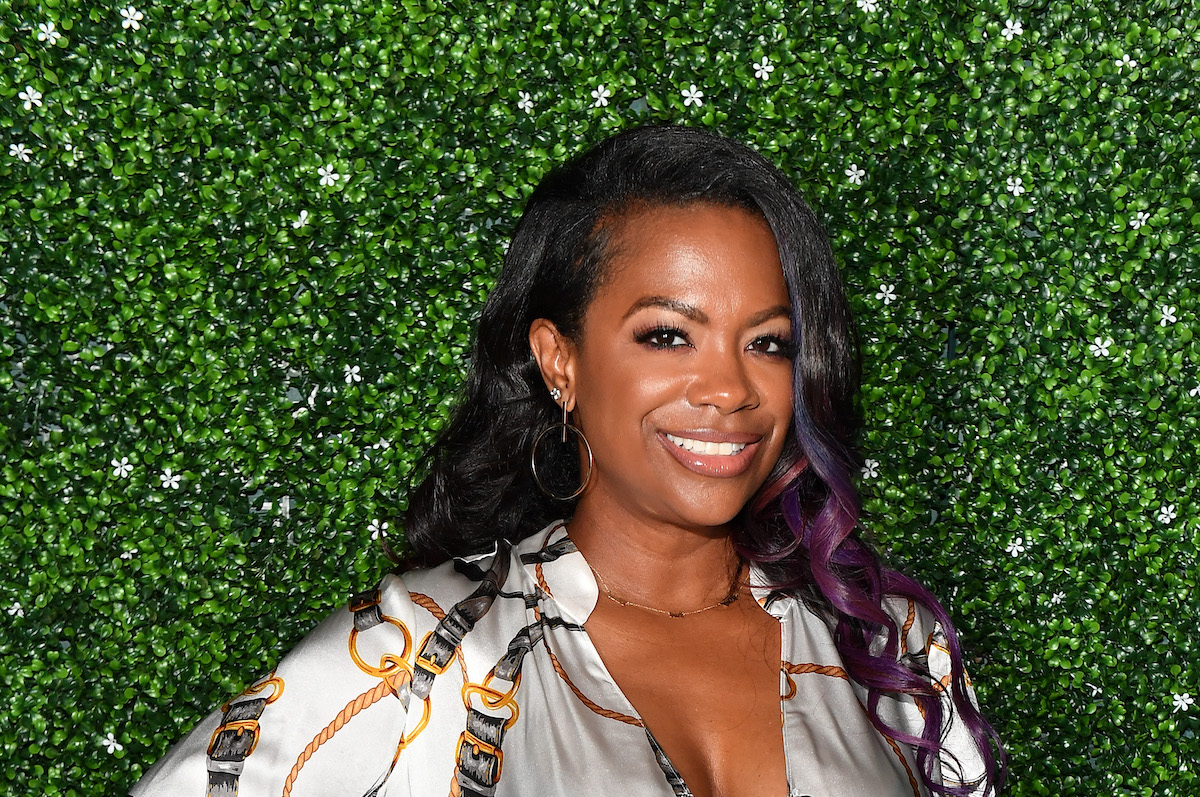 Kandi Burruss debout devant des haies