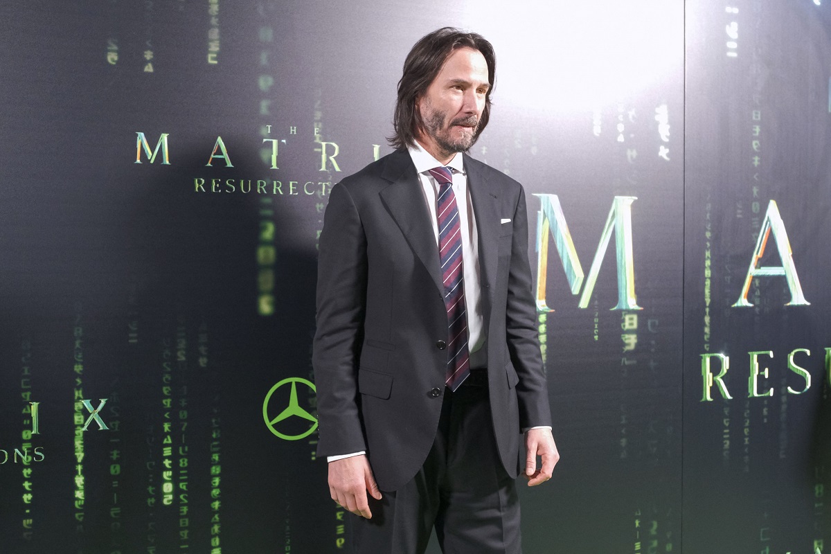 Keanu Reeves posant en portant un costume.