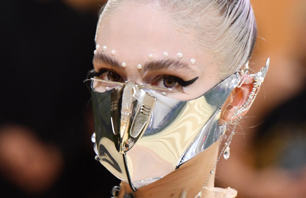 L'artiste musical Grimes arrive au Met Gala 2021 avec un masque facial en métal argenté