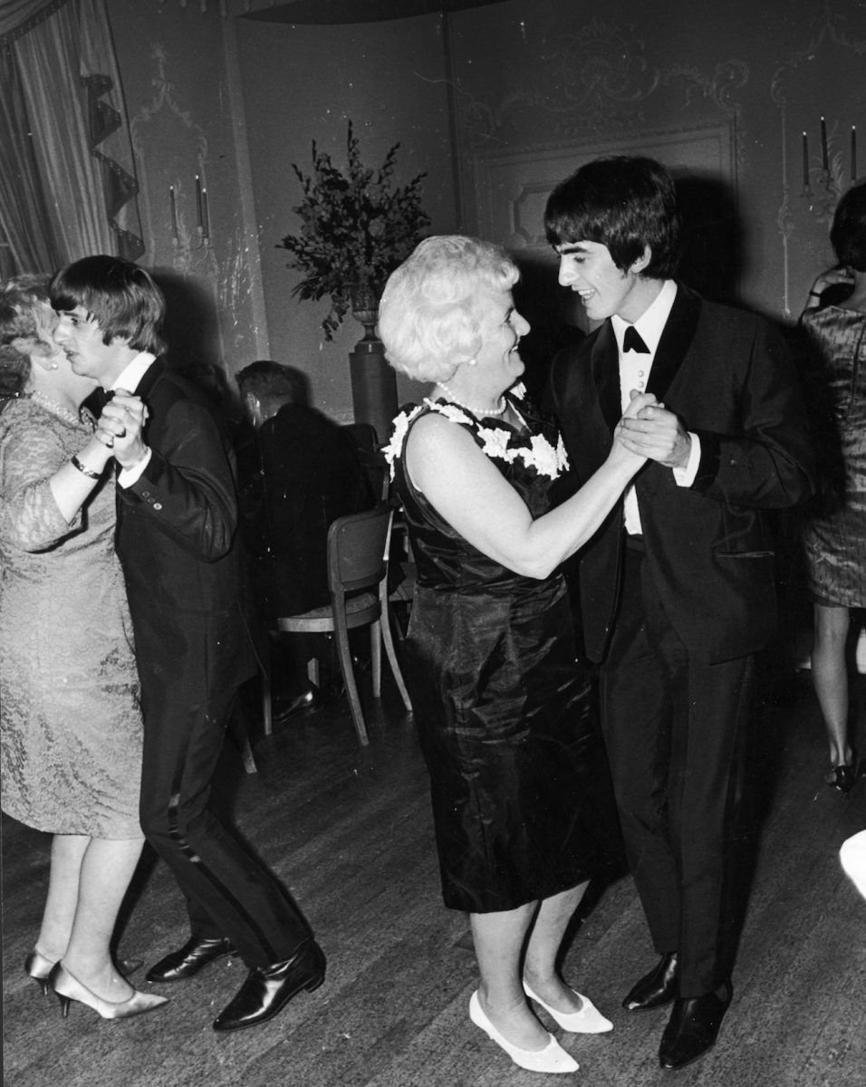 George Harrison vêtu d'un costume en dansant avec sa mère, Louise, en 1964.