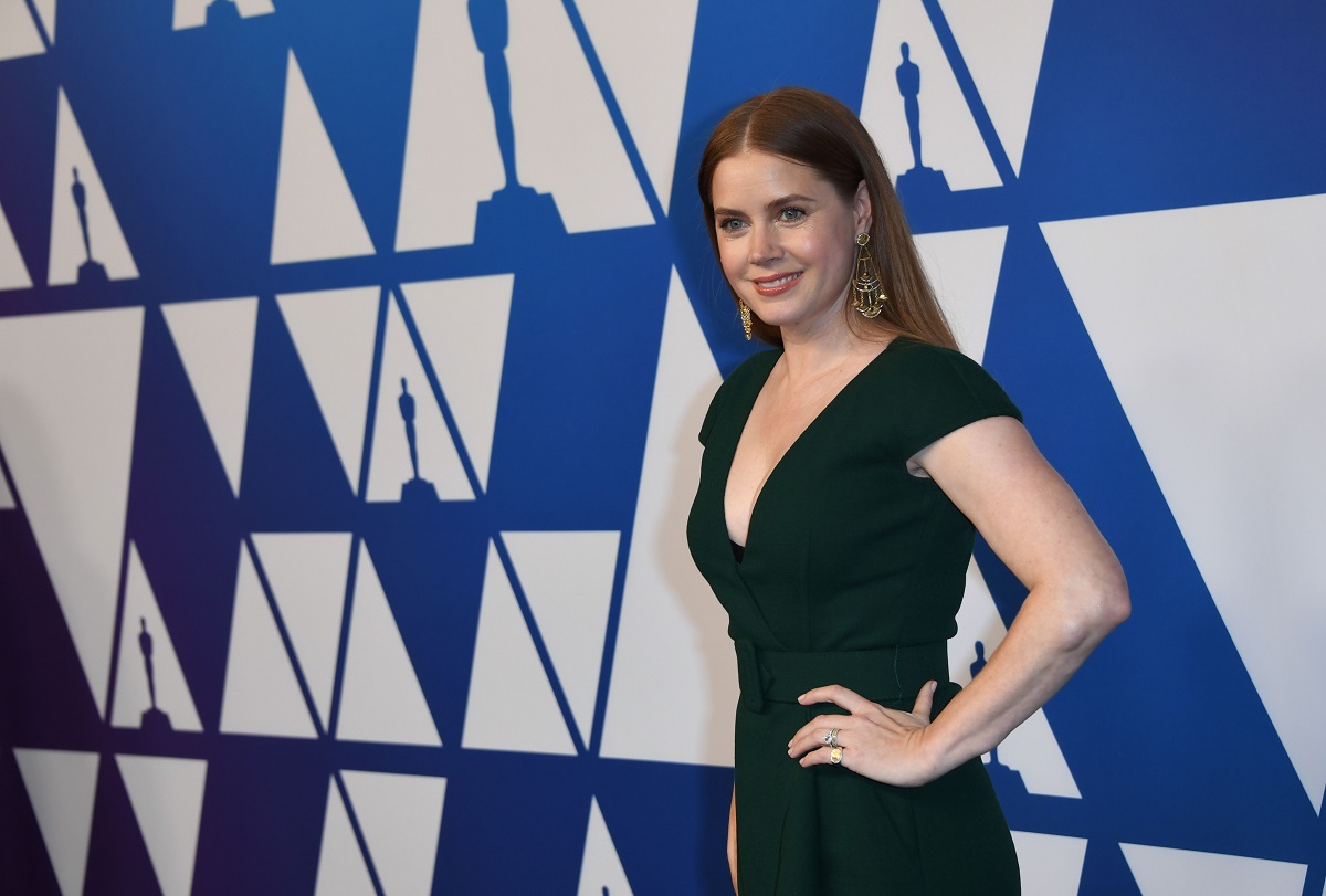 Amy Adams souriante en portant une robe verte.