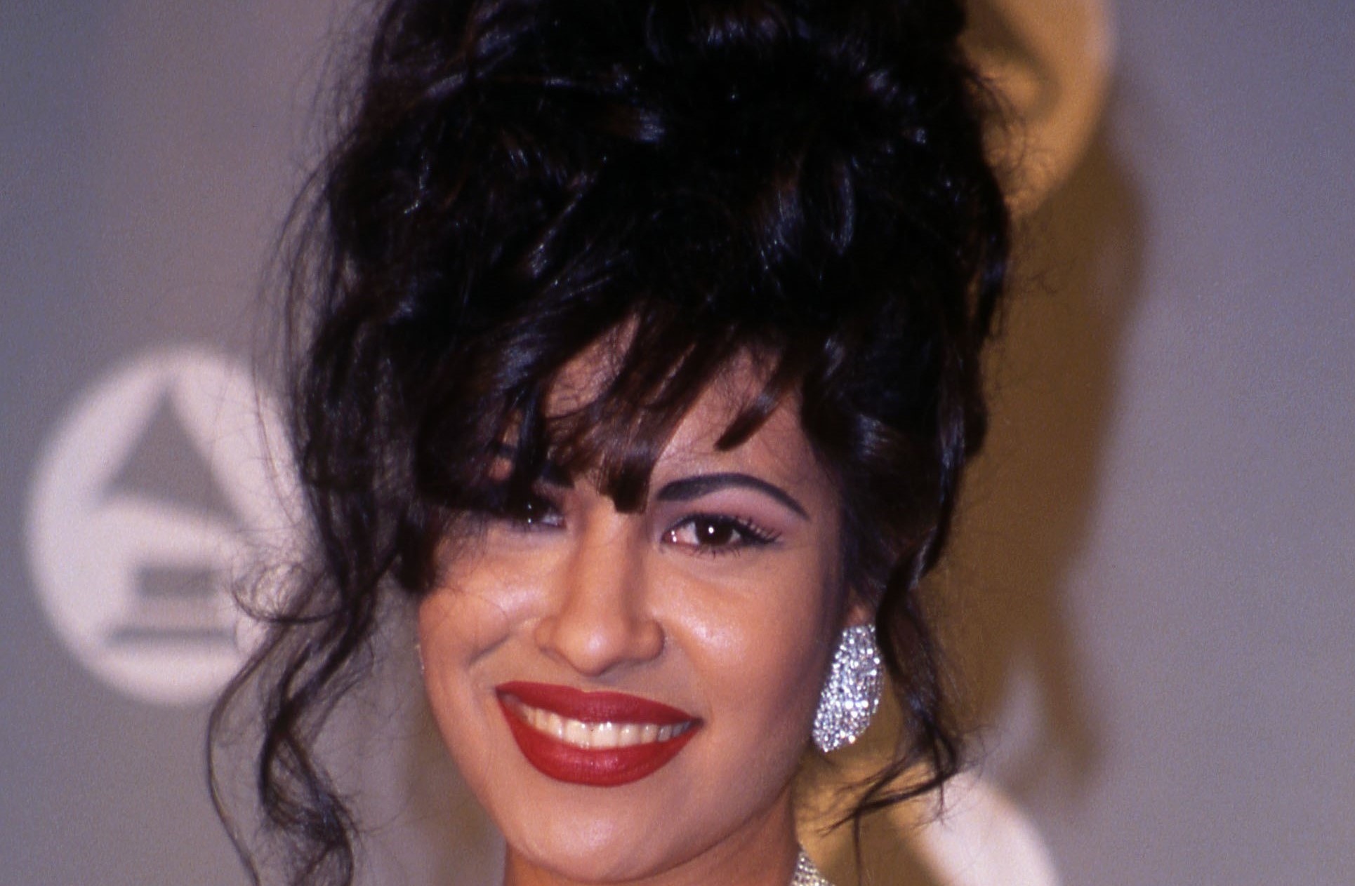 Selena souriant portant du rouge à lèvres rouge
