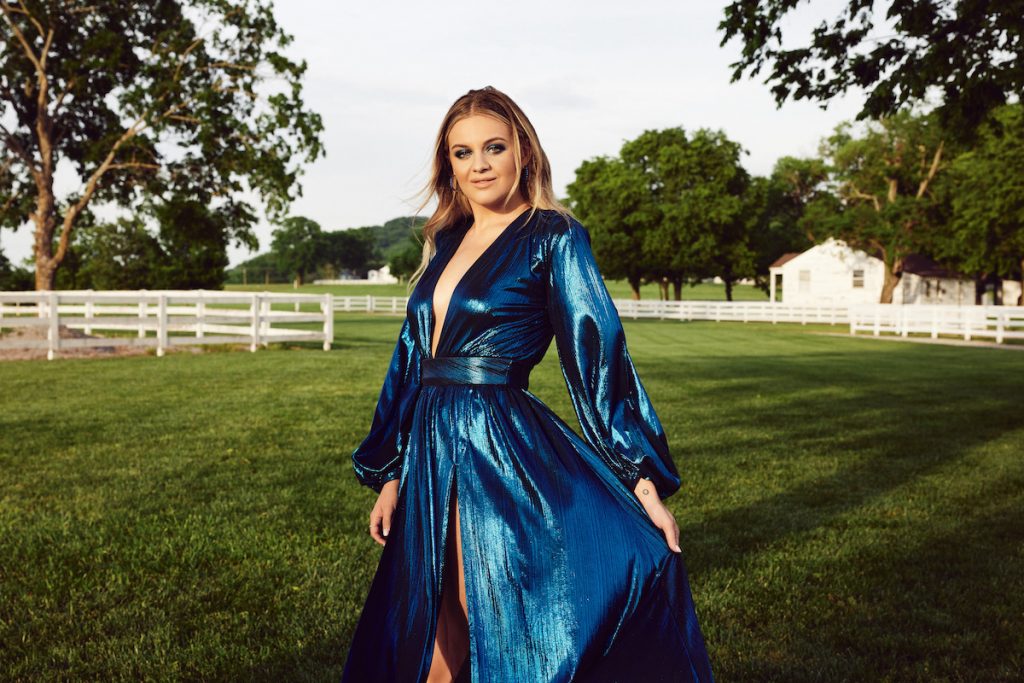 La chanteuse country Kelsea Ballerini porte une robe bleue brillante tout en posant dans une ferme à Nashville, Tennesse