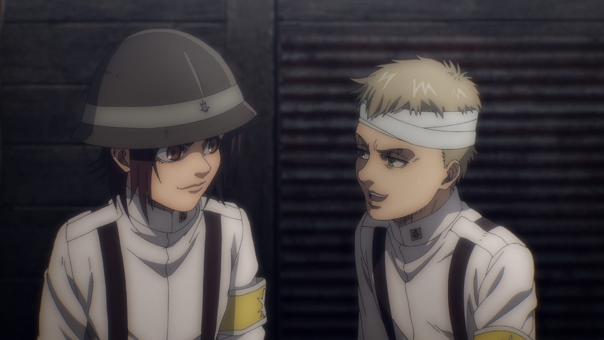 Gabi et Falco dans 'Attack on Titan' Saison 4 Partie 1. Ils sont côte à côte dans les tranchées.  Ils se sourient et la tête de Falco est bandée.