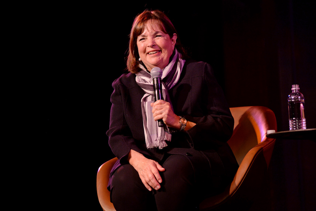 Ina Garten sourit alors qu'elle est assise sur une chaise tenant un microphone
