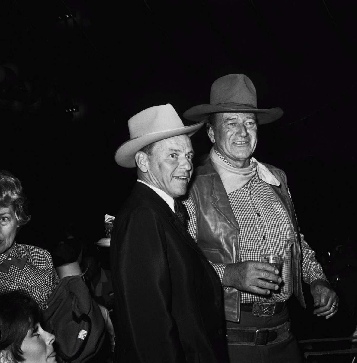 Une photo en noir et blanc de Frank Sinatra et John Wayne portant des chapeaux de cow-boy.