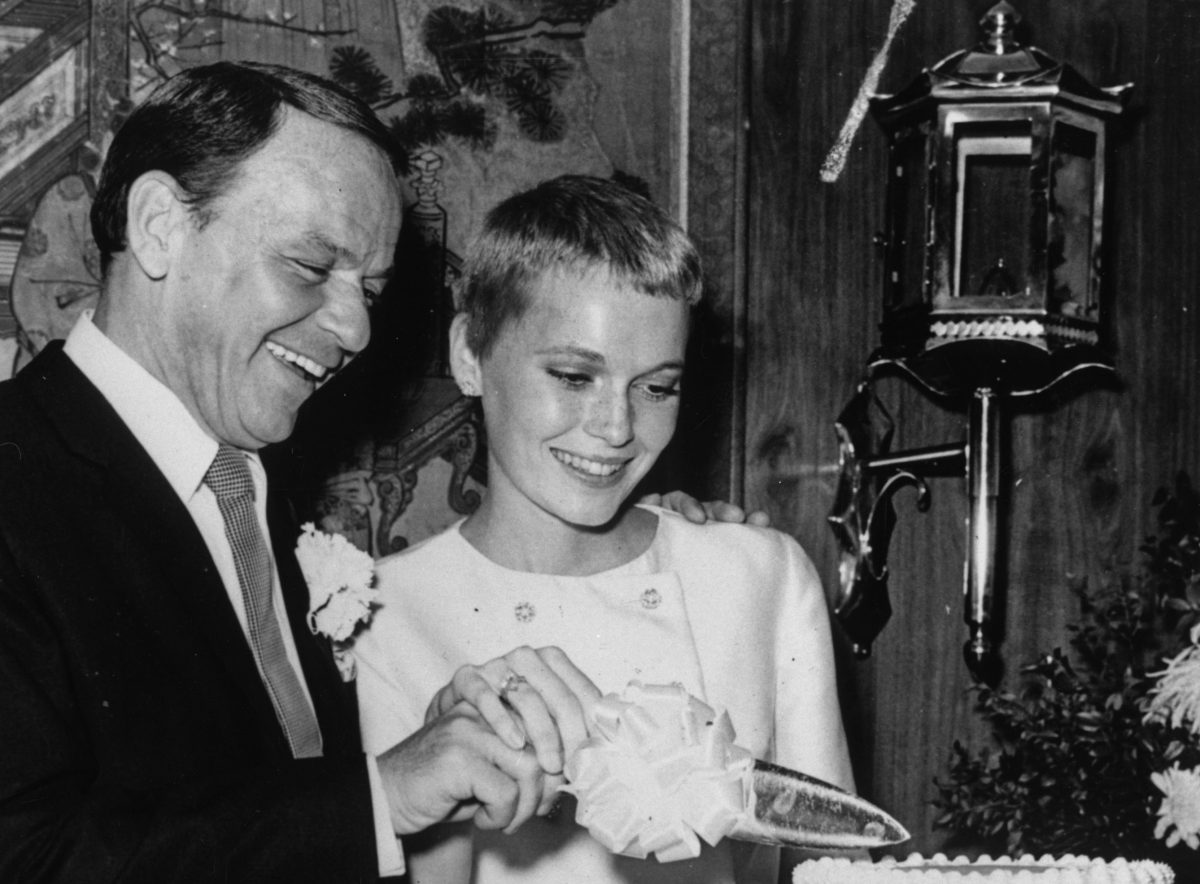 Une photo en noir et blanc de Frank Sinatra et Mia Farrow coupant un gâteau ensemble.