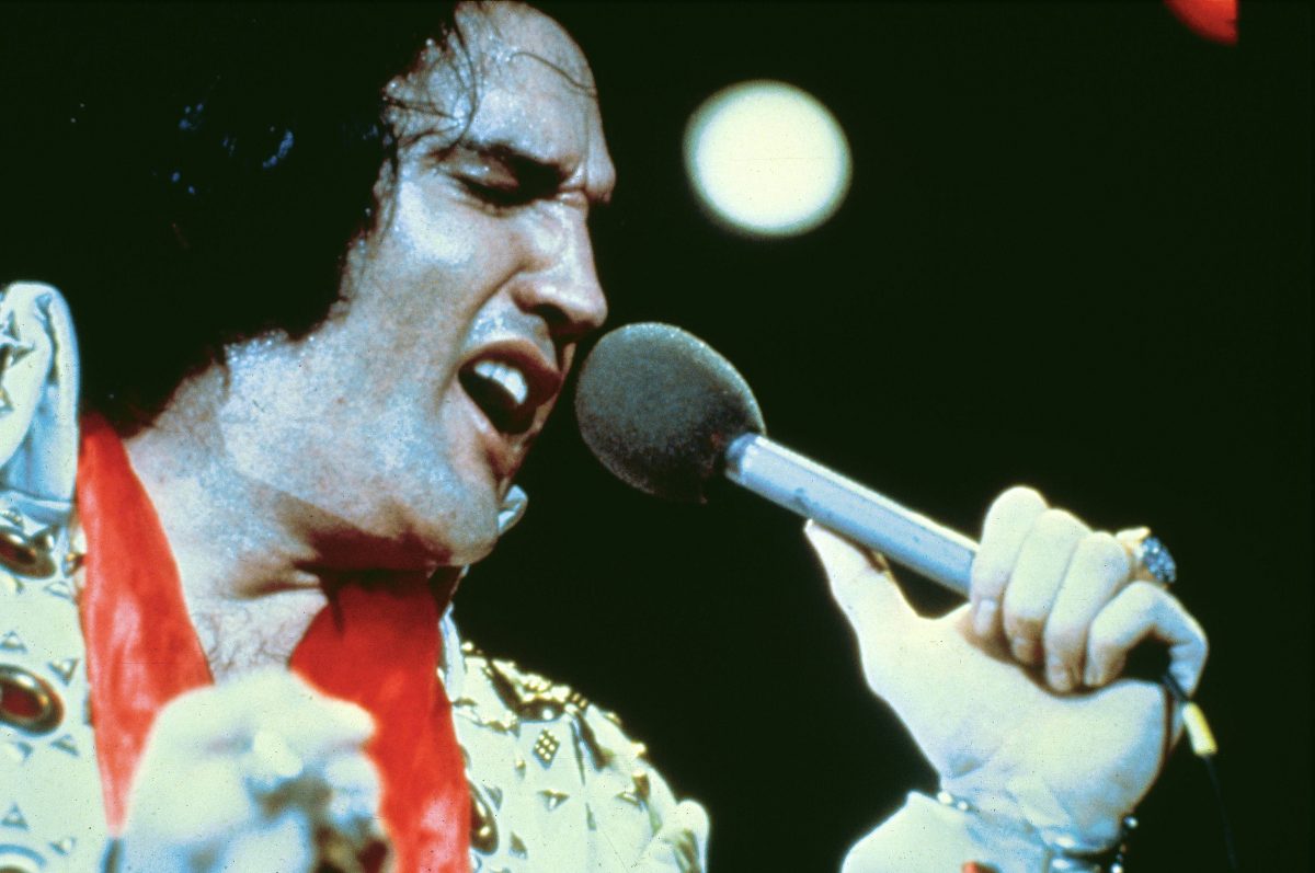 Elvis Presley chantant une chanson dans un micro