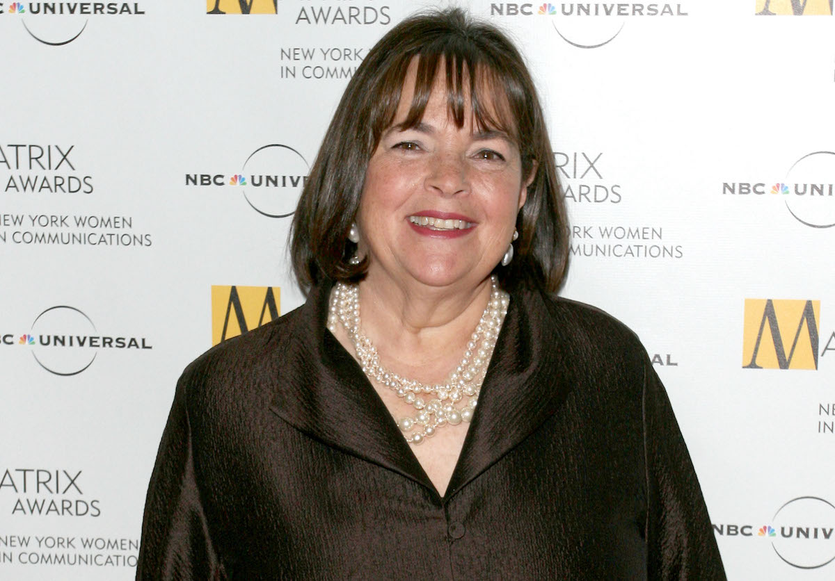 Barefoot Contessa Ina Garten sourit portant des colliers de perles et une chemise marron