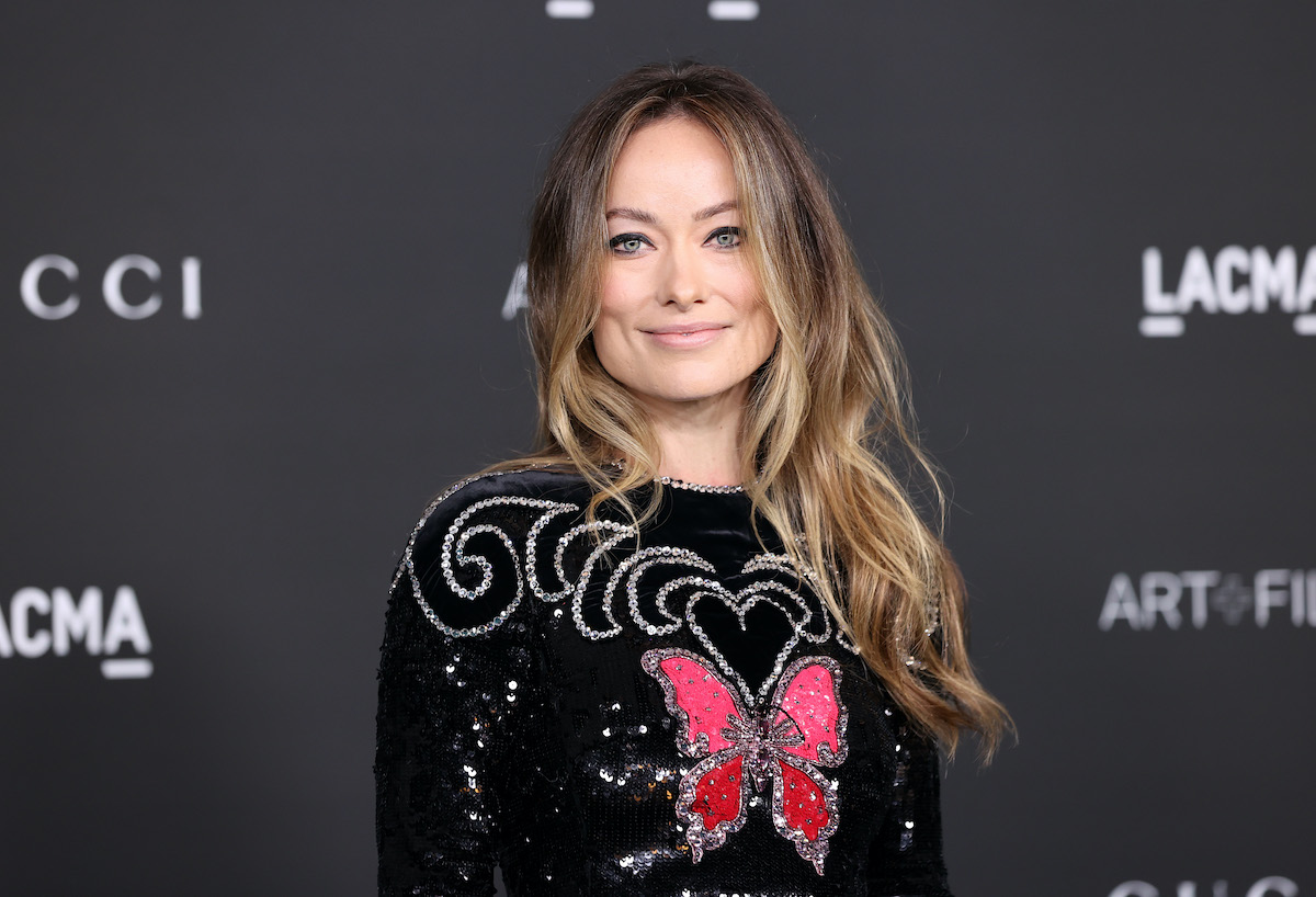 Olivia Wilde souriant devant un fond noir