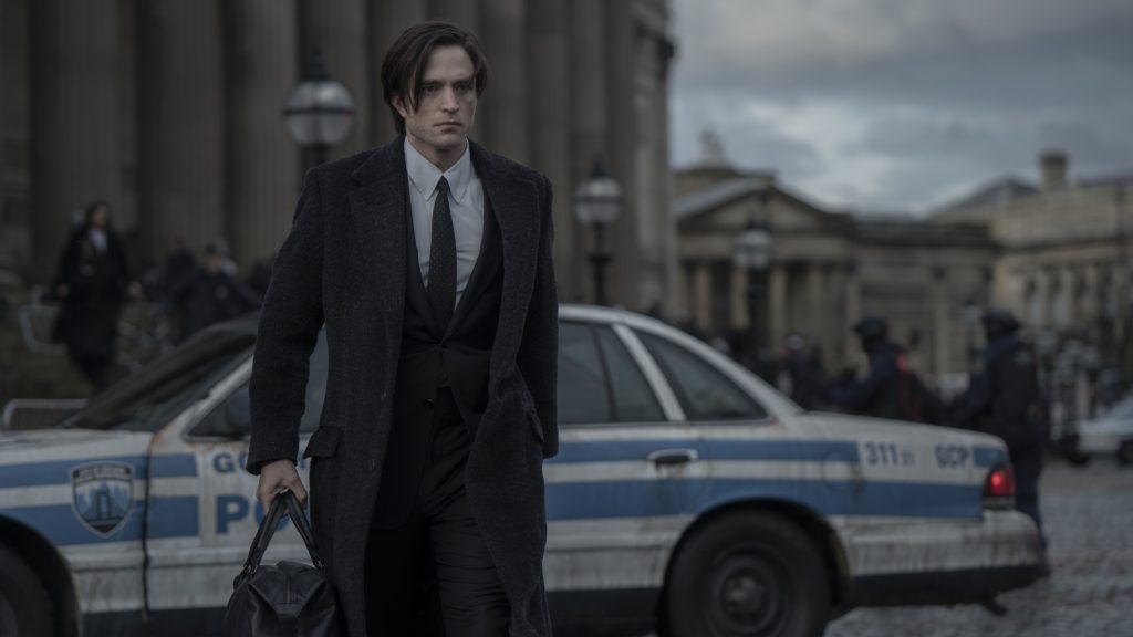 'The Batman' Robert Pattinson dans le rôle de Bruce Wayne/Batman tenant un sac dans un costume