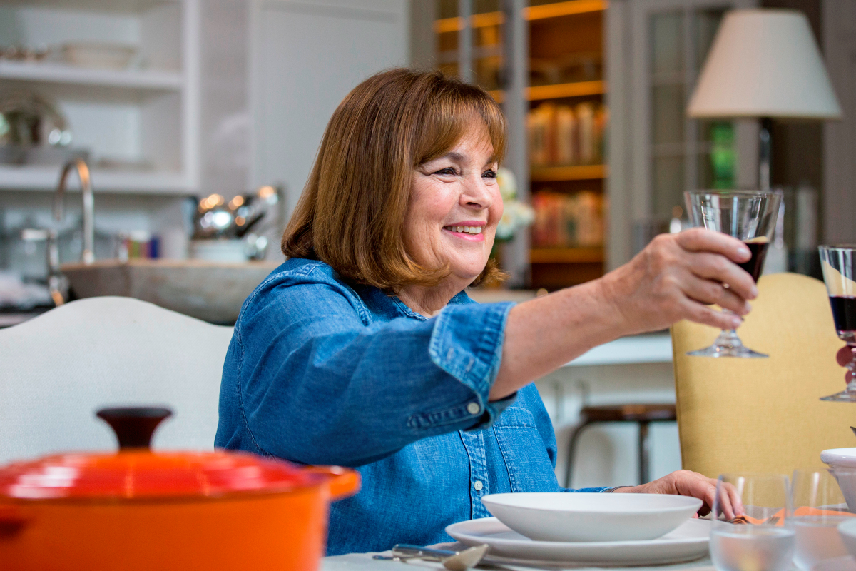 La star de Barefoot Contessa Ina Garten dans sa chemise en chambray signature assise pour le dîner avec un verre de vin en octobre 2018