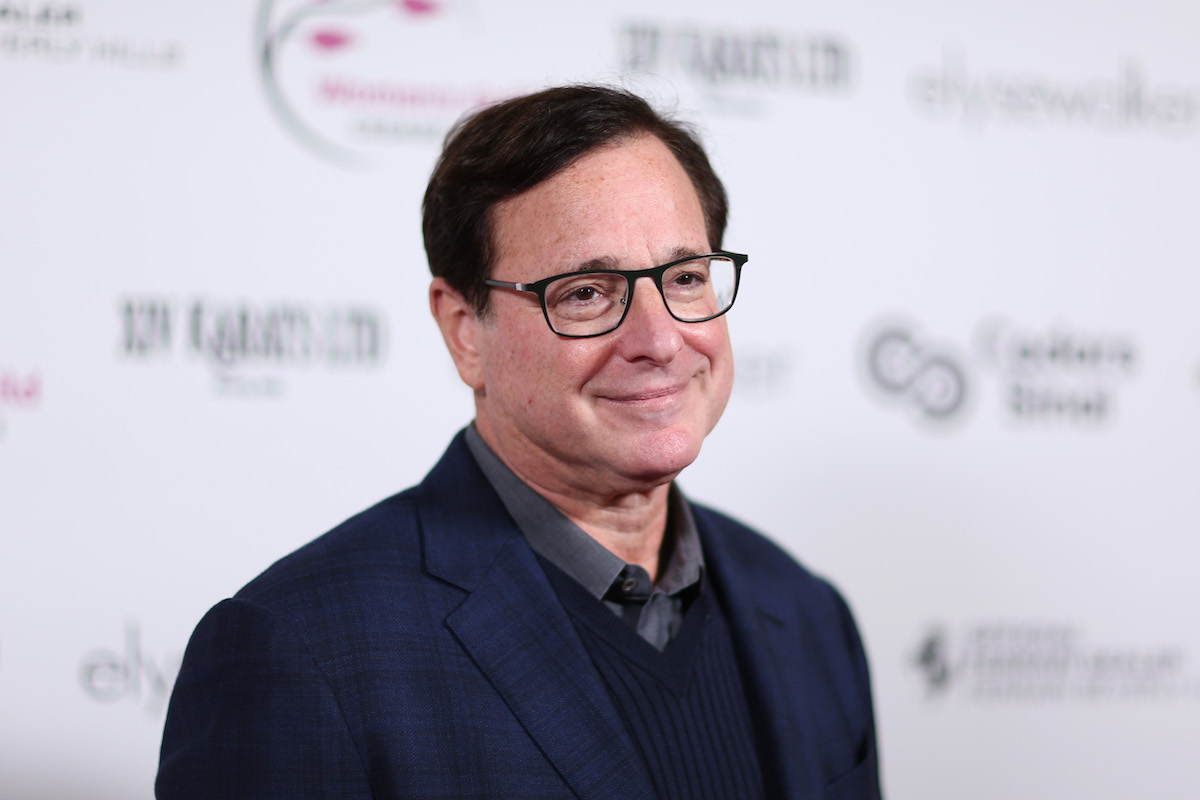 Bob Saget sourit et pose lors d'un événement.