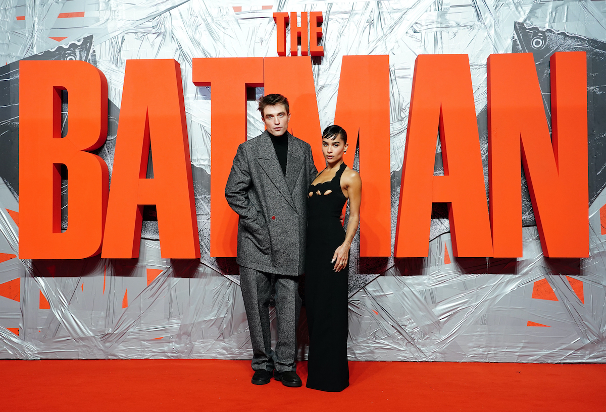 Robert Pattinson et Zoe Kravitz posent devant le logo