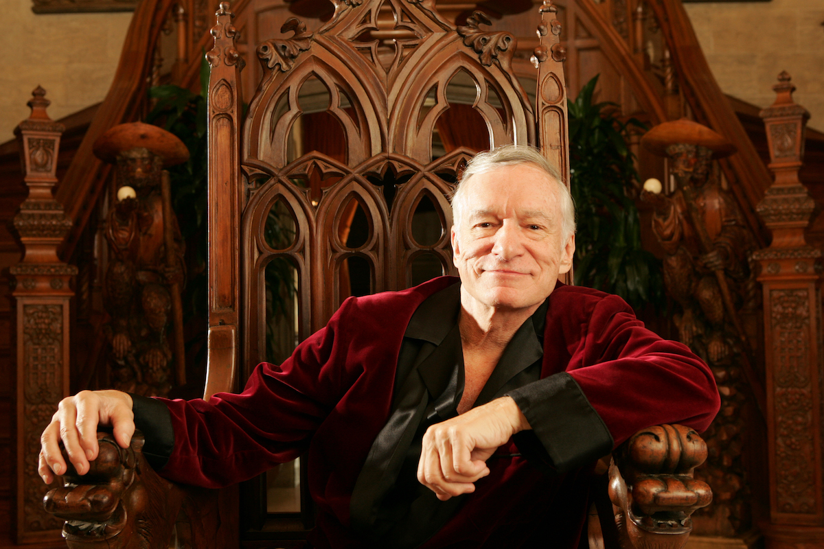 Valeur nette de Hugh Hefner: le fondateur de Playboy, Hugh Hefner, pose dans une robe rouge foncé sur un trône le 17 novembre 2005