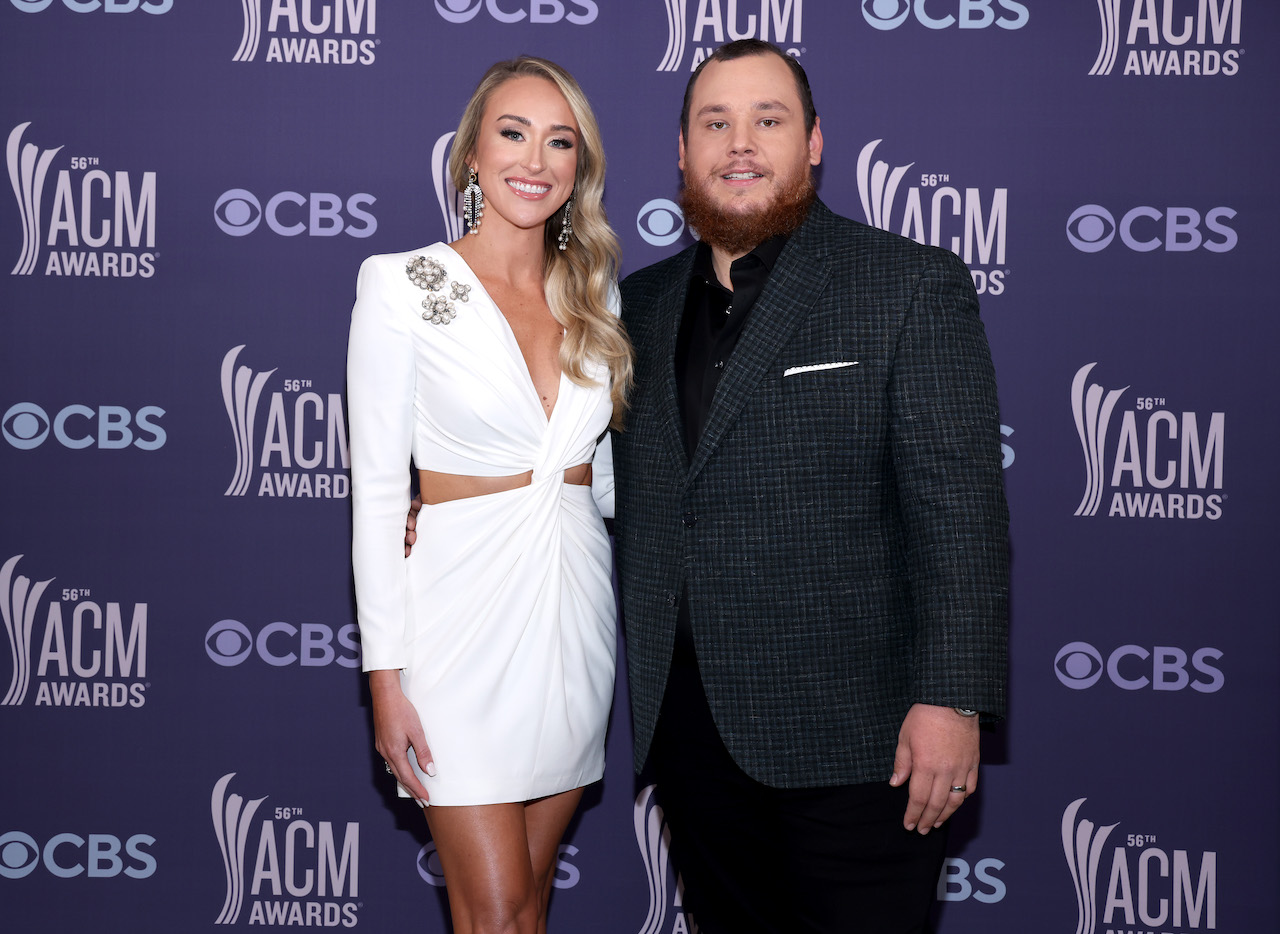 Nicole Hocking en robe blanche debout à côté de son mari, Luke Combs, en costume noir