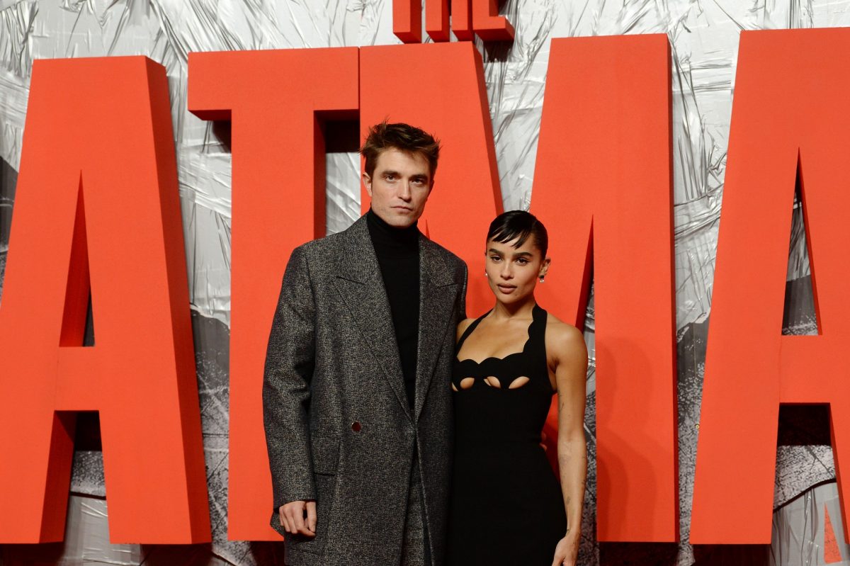 Robert Pattison et Zoe Kravitz posent devant le panneau The Batman lors de la première du film.
